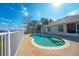 Kidney-shaped pool with a patio and white fence overlooking a lake at 2370 Alton Rd, Deltona, FL 32738