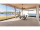 Spacious screened porch overlooking a lake with seating for four at 238 Venetian Palms Blvd, New Smyrna Beach, FL 32168