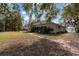 Expansive backyard of a brick home with a walkway and mature trees providing shade and privacy at 2424 India Blvd, Deltona, FL 32738