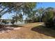 Lush backyard featuring mature trees and a tranquil lake view, perfect for relaxation at 2424 India Blvd, Deltona, FL 32738