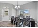 Dining room features a modern chandelier, wood-look flooring, and a view of the lake at 2424 India Blvd, Deltona, FL 32738