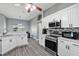 Well-lit kitchen with quartz counters, white cabinets, and stainless steel appliances at 2424 India Blvd, Deltona, FL 32738