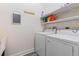 Bright laundry room featuring a washer and dryer set, shelving, and utility sink at 2424 India Blvd, Deltona, FL 32738
