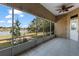 Screened-in patio with brick walls, ceiling fan, and tile flooring overlooking the serene lake and backyard at 2424 India Blvd, Deltona, FL 32738