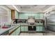 Kitchen with light green cabinets, stainless steel appliances, and tile floor at 2625 Sweet Springs St, Deltona, FL 32738