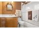Bathroom with a shower/tub combo, wood cabinets, and decorative wallpaper at 2806 Bay Vista Ct, New Smyrna Beach, FL 32168