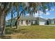 Single-story home with a grassy yard, oak trees, and a neutral color scheme at 2909 Desmond Ct, Deltona, FL 32738