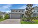 Two-story home with gray siding, two-car garage, and landscaped front yard at 3009 Lake Tahoe St, Deland, FL 32724