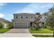 Two-story house with gray siding, a two-car garage, and a landscaped front yard at 3009 Lake Tahoe St, Deland, FL 32724