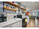 Contemporary kitchen featuring white cabinets, floating wood shelves, and backsplash at 30215 Tavares Ridge Blvd # 11, Tavares, FL 32778