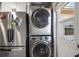 Convenient laundry area with stacked washer and dryer next to stainless steel refrigerator at 30215 Tavares Ridge Blvd # 11, Tavares, FL 32778