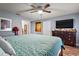 Well-lit main bedroom with ceiling fan, wood-look floors, and light gray walls at 30215 Tavares Ridge Blvd # 11, Tavares, FL 32778