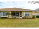 Home's back exterior showcasing screened patio and yard at 3162 Kailani Ct, Ormond Beach, FL 32174