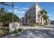 Tuscan Square Condominiums building with palm trees and gated entrance at 424 Luna Bella Ln # 332, New Smyrna Beach, FL 32168