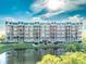 Beautiful condo building overlooking a serene pond, featuring a charming coastal aesthetic and lush greenery at 4672 Riverwalk Village # 8406, Ponce Inlet, FL 32127