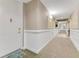 Inviting hallway with neutral tones, decorative art, and a welcome mat that says 
