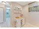 Bright hallway with decorative shelves and a serving cart, leading to an adjacent room with coastal decor at 4672 Riverwalk Village # 8406, Ponce Inlet, FL 32127