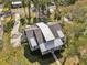 Striking architectural design highlighted by mixed metal roof, lush surroundings, and mature trees at 475 W Main St, Lake Helen, FL 32744