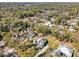 Aerial view of a neighborhood with houses and lush green trees at 475 W Main St, Lake Helen, FL 32744