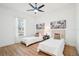 Bright bedroom featuring two beds, neutral decor, artwork, and wood-look floors at 475 W Main St, Lake Helen, FL 32744