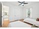 Bright bedroom features two twin beds, wood-look tile flooring, and a bathroom view at 475 W Main St, Lake Helen, FL 32744