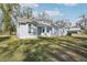 Single-Gathering home in light blue with a lush green lawn and mature trees at 475 W Main St, Lake Helen, FL 32744