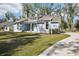 A beautifully landscaped single-Gathering home with a well-manicured lawn and blue siding at 475 W Main St, Lake Helen, FL 32744