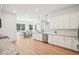 Bright kitchen features white cabinetry, stone countertops, stainless steel appliances, and an adjacent dining area at 475 W Main St, Lake Helen, FL 32744