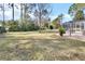 Expansive grassy backyard with mature trees and a patio at 675 Winterberry Trl, Deland, FL 32724