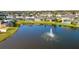 Aerial view of a lake with houses and a fountain in a community at 6832 Forkmead Ln, Port Orange, FL 32128