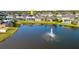Aerial view of a house with a pool and a lake in a residential area at 6832 Forkmead Ln, Port Orange, FL 32128