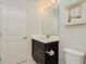 Modern bathroom with dark vanity, white countertop, and a large mirror at 6832 Forkmead Ln, Port Orange, FL 32128