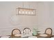 Bright dining room features a rustic wooden table with seating for six and a modern chandelier at 6832 Forkmead Ln, Port Orange, FL 32128