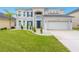 Two-story house with gray exterior, stone accents, and a three-car garage at 6832 Forkmead Ln, Port Orange, FL 32128