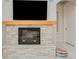 Modern fireplace with stone surround and a wood mantel, below a mounted TV at 6832 Forkmead Ln, Port Orange, FL 32128
