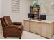 Home office with a large desk, comfortable leather chair, and built-in shelves at 6832 Forkmead Ln, Port Orange, FL 32128