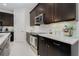 Modern kitchen with dark cabinets, white subway tile backsplash and stainless steel appliances at 6832 Forkmead Ln, Port Orange, FL 32128