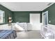 Bright Bedroom with dark green walls, white trim, and a changing table and crib at 728 Vicksburg St, Deltona, FL 32725