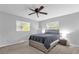 Neutral bedroom with a ceiling fan, a bed with gray bedding, and windows at 728 Vicksburg St, Deltona, FL 32725