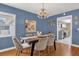 Dining room with blue walls, hardwood floors, and a view into the modern kitchen at 728 Vicksburg St, Deltona, FL 32725