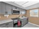 Modern kitchen with stainless steel appliances, sleek gray cabinetry, and ample counter space at 728 Vicksburg St, Deltona, FL 32725