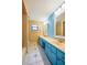 Bathroom featuring double sinks, light blue cabinets, neutral tile, and shower with beige tile at 949 Tall Pine Dr, Port Orange, FL 32127