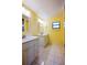 Bright bathroom with yellow plank walls, dual vanity with white cabinets, stylish mirrors and tile floors at 949 Tall Pine Dr, Port Orange, FL 32127