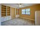 Bright bedroom features built-in shelves, cabinets, neutral carpet, and a ceiling fan at 949 Tall Pine Dr, Port Orange, FL 32127