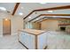 Bright living room features wood beams, stone fireplace and kitchen island with wooden countertop and white cabinets at 949 Tall Pine Dr, Port Orange, FL 32127