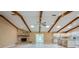 Open-concept living room with a stone fireplace, vaulted ceilings with wood beams, and a seamless flow into the kitchen at 949 Tall Pine Dr, Port Orange, FL 32127