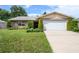 Brick ranch house with a two-car garage and well-maintained lawn at 1016 Martex Dr, Apopka, FL 32703