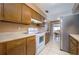 Kitchen with wood cabinets, white appliances, and adjacent dining area at 1016 Martex Dr, Apopka, FL 32703