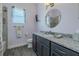 Bathroom features a granite vanity, round mirror, and a shower with tiled walls at 105 Cerise Ct, Daytona Beach, FL 32124
