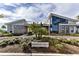 Exterior of a modern Residents Club building, landscaped with trees and a sign that reads, 